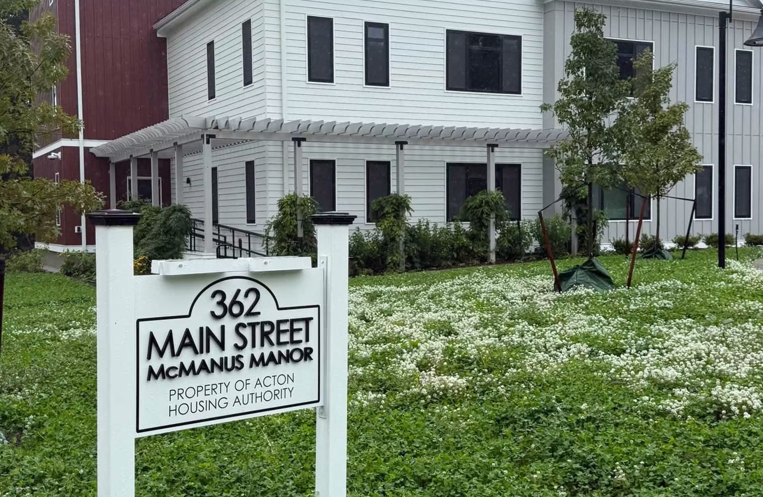 Sign reading 362 Main Street McManus Manor, property of Acton Housing Authority, in front of the senior apartment building